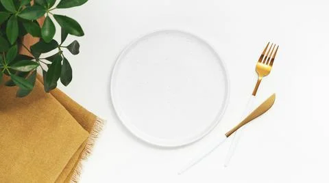 Empty plate with fork and knife on white background. Top view. Stock Photos