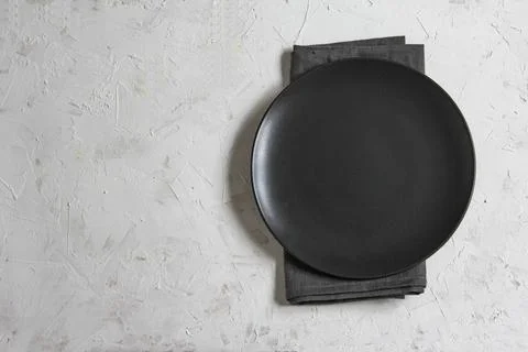 Empty plate on grey table and napkin. Food background for menu, recipe. Stock Photos