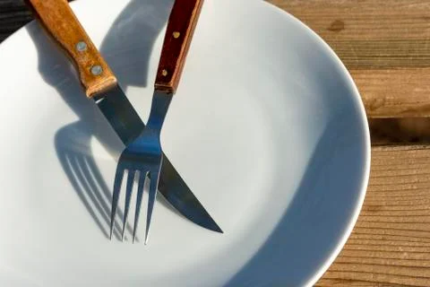 Empty plate with knife and fork Stock Photos