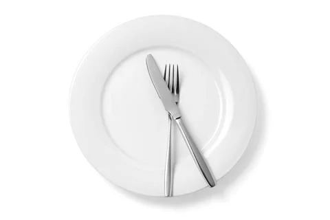 Empty plate with knife and fork isolated on a white background. Stock Photos
