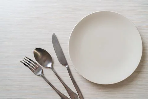 Empty plate or dish with knife, fork and spoon Stock Photos