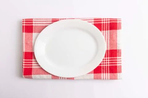 Empty plate, red checkered textile on white background 库存照片