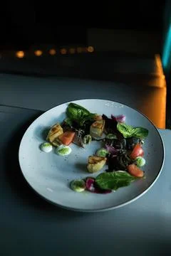 Empty plate with salad on dark table at night Stock Photos