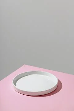 Empty plate with shadow on pink background. Copyspace Stock Photos