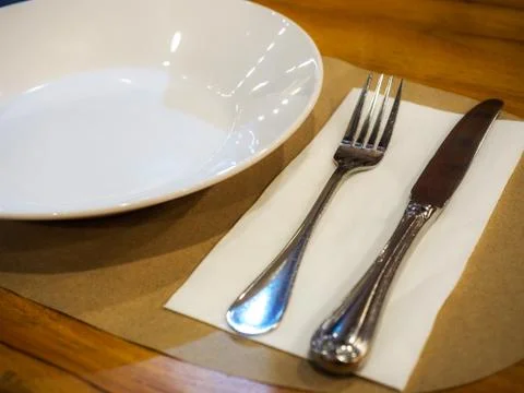 Empty plate with spoon and fork on wooden background Stock Photos