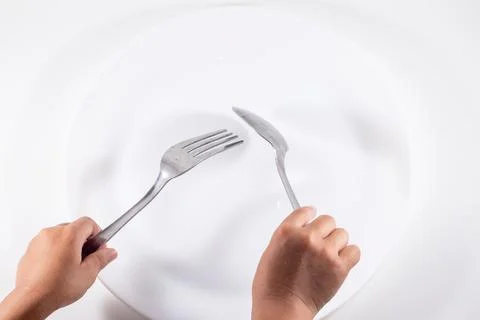 A empty plate with spoon and fork isolated on white background Stock Photos
