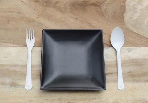 Empty plate with spoon and fork ,top view. on wood background Stock Photos