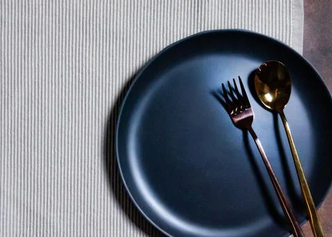 Empty plate with spoon and fork on Napery background, table setting Stock Photos