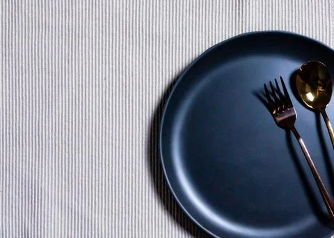 Empty plate with spoon and fork on Napery background, table setting Stock Photos