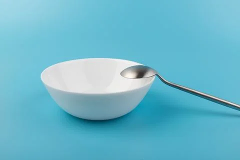 Empty plate with spoon on blue background. Flat lay Dishes for breakfast, lun Foto stock
