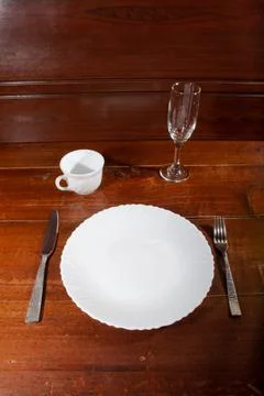 Empty plate spoon fork and knife on table Foto stock
