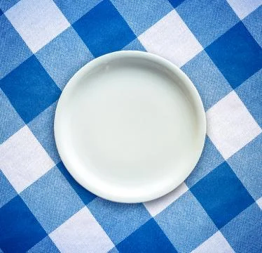Empty plate on tablecloth Stock Photos