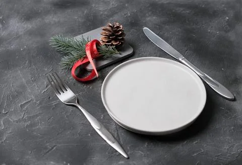 Empty plate with tableware and christmas decor on grey table. copy space. t.. Stock Photos