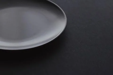Empty plates on black background, premium dishware for holiday dinner Stock Photos