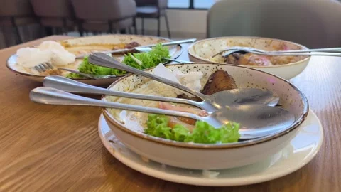 Empty Plates with Food Leftovers on a Dining Table Stock Footage 338427196