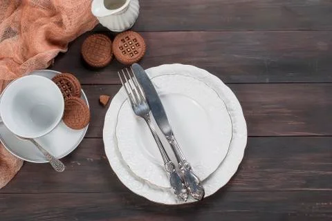 Empty plates,fork,  knife  and cup on wooden table 库存照片