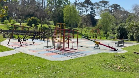 Empty Playground with Climbing Frame, Swings, and Slide in Park Setting Stock Footage 346495323