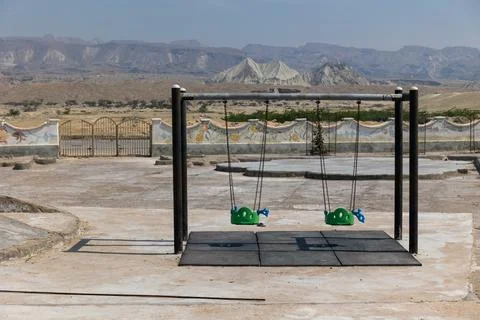Empty playground in the desert with mountains in the back Stock Photos