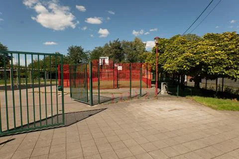 Empty playground gate under bright blue sky Stock Photos