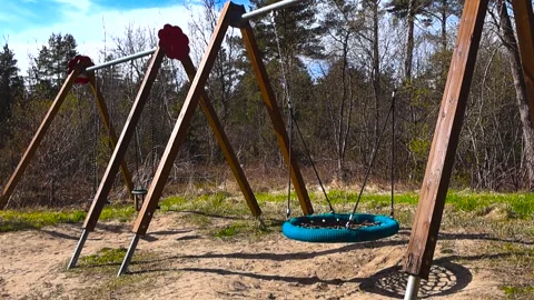 Empty Playground Nest Swing Swinging on a Sunny Day Stock Footage 335189919