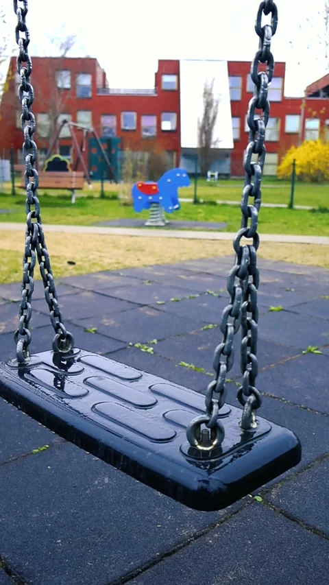 Empty Playground Swing Moving in the Rain Stock Footage 335133755