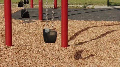 Empty Playground Swing Swaying in Slow Motion Stock Footage 345974199