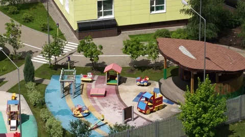 Empty playground with swings and carousel in sunny weather. Video stock 134730563