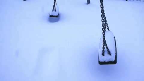 Empty Playground Swings Moving in the Winter Snow Stock Footage 334648270