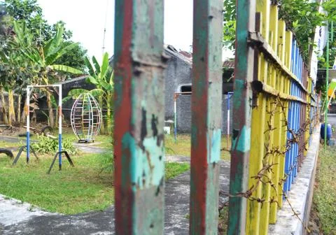 Empty playground without child visible from outside the old of iron fence Stock Photos