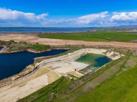 An empty plot of land with ponds and grassy areas near the coast. The sky is  Stock Photos