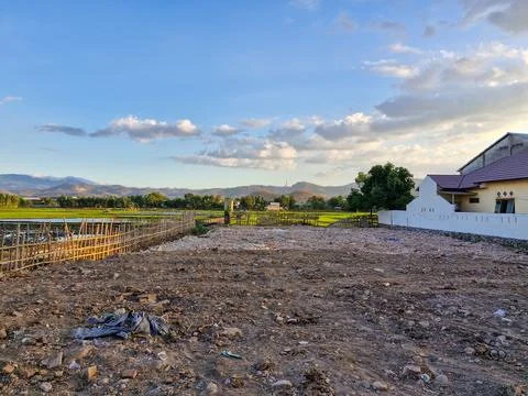 An empty plot of land, ready for construction, surrounded by lush green ric.. Stock Photos