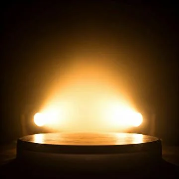 An empty podium in a dark room with bright lights for product display Stock Photos