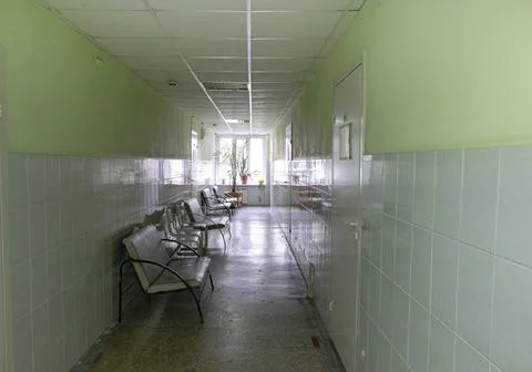 Empty polyclinic corridor with doctors' offices and patient chairs Stock Photos