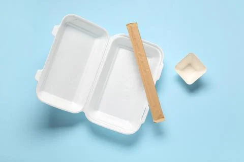 Empty polystyrene food container with chopsticks on blue background Stock Photos