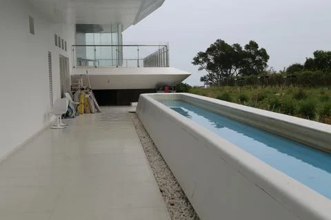 An empty pool in the shape of a long and thin rectangle, on the top floor o.. Stock Photos