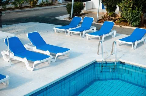 Empty Poolside with Blue Sun Loungers Stock Photos