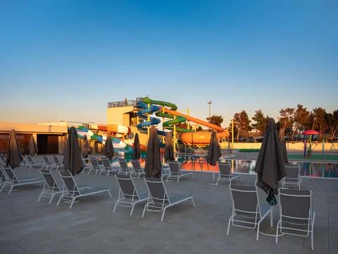 Empty Poolside with Water park at sunset Stock Photos