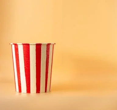 Empty popcorn bucket on an orange background Stock Photos
