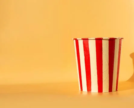 Empty popcorn bucket on an orange background Stock Photos