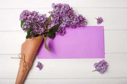 Empty postal envelope and bouquet of lilac flowers Stock Photos