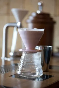 Empty pour over with paper filter on a wooden table in cofffee shop Stock Photos