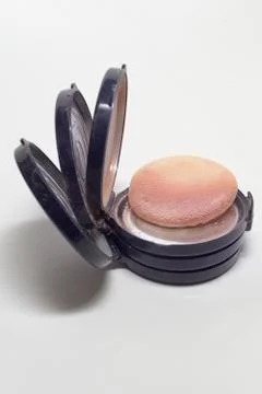 Empty powder boxes, lying on each other and one used sponge puff. Closeup Stock Photos