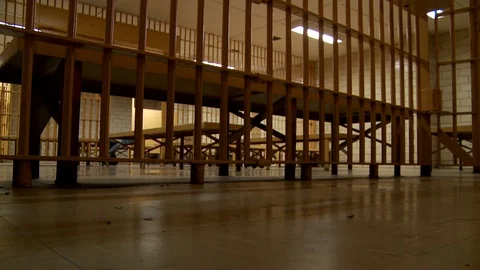 Empty prison cells in correctional facility with cell bars in foreground. Video stock 106459919