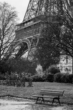 Empty public bench at the foot of the Eiffel Tower in Paris in black and whit Stock Photos
