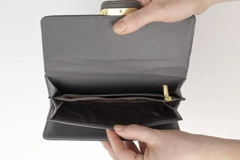 An empty purse in women's hands. The concept of poverty. A woman opens an empty Stock Photos