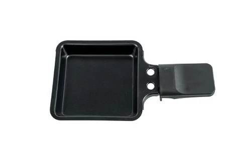 Empty raclette mould from processed cheese, close-up. Stock Photos