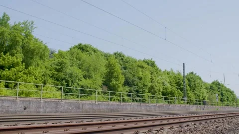 Empty Railway Tracks with Lush Green Trees and Blue Sky on Clear Sunny Day Stock Footage 334054890