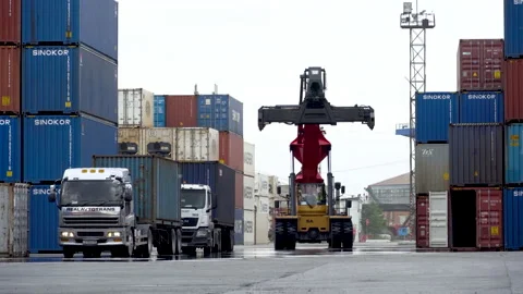 An empty reachstacker travels between containers at a seaport logistics port. Stock Footage 148598314