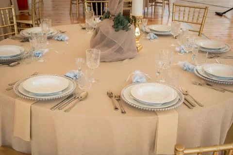 Empty Reception Hall Table Setting With Beige Tablecloth and Gold Chiavari Stock Photos