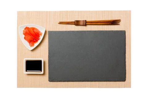 Empty rectangular black slate plate with chopsticks for sushi, ginger and soy Stock Photos